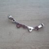 DIJE DE ACERO PERCHA X2  30 X 8 MM. (Separación entre argollas para enganchar nenitos 15 MM)
