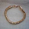 PULSERA DE ACERO DORADO TUBO TEJIDO GRUESO.