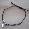 PULSERA DE HILO NEGRO AJUSTABLE CON BOLITAS Y DIJE CORAZÓN DE ACERO.