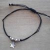 PULSERA DE HILO NEGRO AJUSTABLE CON BOLITAS Y DIJE ESTRELLA DE ACERO.
