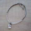 PULSERA DE ACERO TUBO COMBINADO CON MOSTACILLAS Y DIJE CORAZON CRISTAL. LARGO 18 CM + 4 CM EXT.