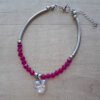 PULSERA DE ACERO TUBO COMBINADO CON MOSTACILLAS FUCSIA Y DIJE CORAZON CRISTAL. LARGO 18 CM + 4 CM EXT.