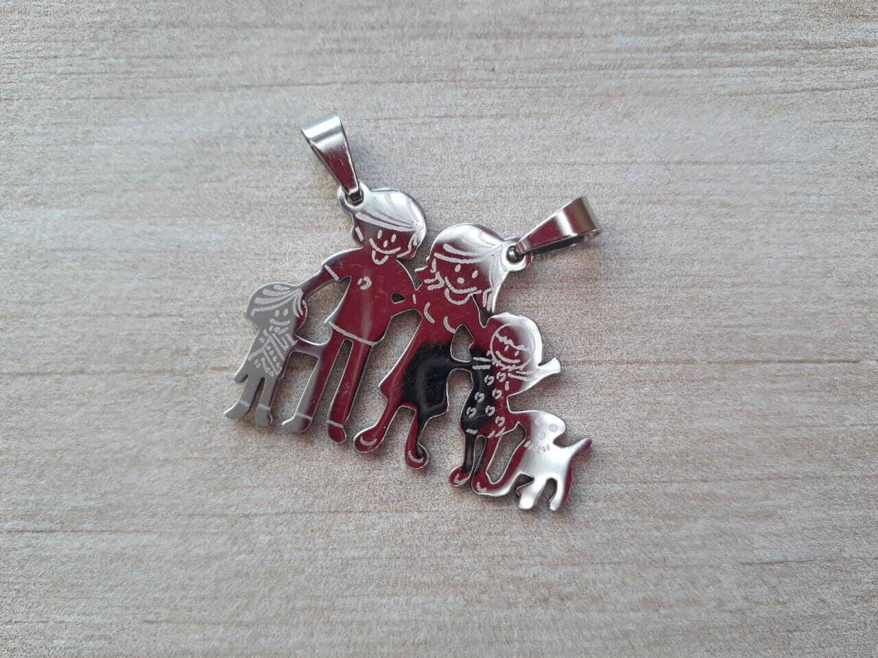 DIJE DE ACERO FAMILIA CON 1 NENA, 1 NENE Y 1 PERRO. 32 X 23 MM