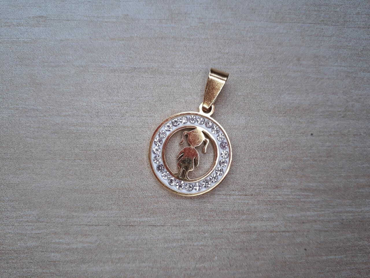 DIJE DE ACERO DORADO NENA CON STRASS ALREDEDOR. DIÁMETRO 20 MM