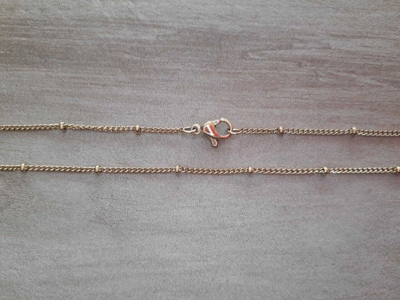 CADENA DE ACERO DORADO GRUMET 0,4 CON BOLITAS.