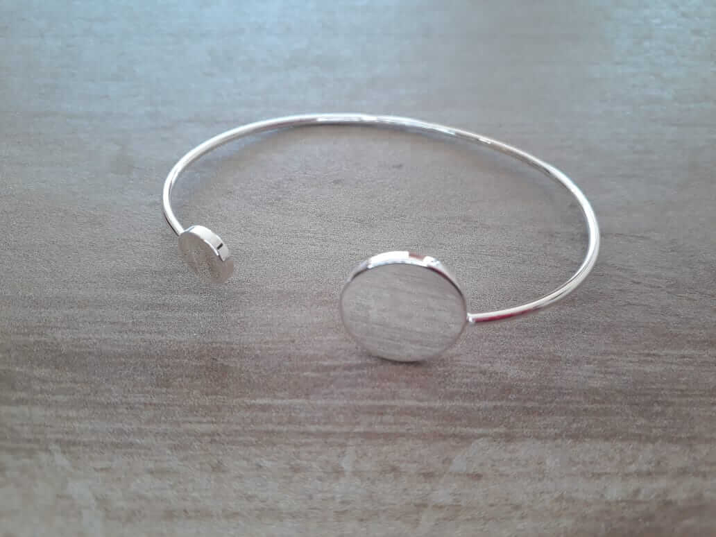 PULSERA DE ACERO BLANCO ESCLAVA ABIERTA CON FIGURAS REDONDAS EN LOS EXTREMOS