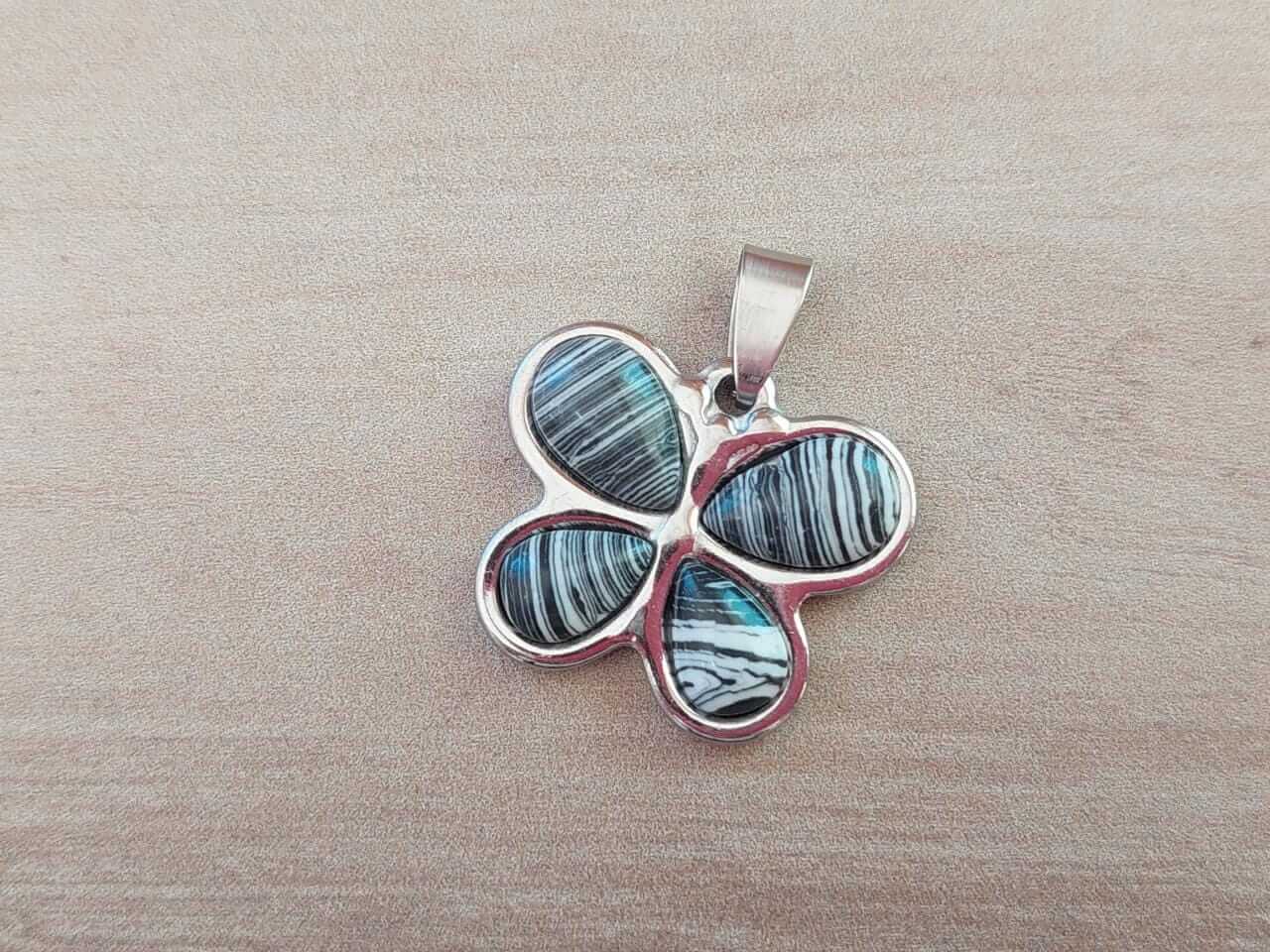 DIJE DE ACERO MARIPOSA PIEDRA NEGRA CON LINEAS BLANCAS. 27 X 24 MM