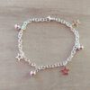 PULSERA DE ACERO BLANCO ESLABÓN TIFFANY CON BOLITAS Y DIJES DE ESTRELLAS. LARGO 18,5 CM