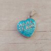DIJE DE ACERO CORAZÓN ESMALTADO CELESTE CON FRASE "MAMA TE AMO". MEDIDA 25 MM