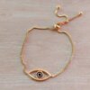 PULSERA DE ACERO DORADO VENECIANA AJUSTABLE CON DIJE OJO CENTRO ESMALTADO