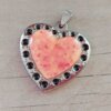 DIJE DE ACERO CORAZÓN ESMALTADO CORAL CON LUNARES NEGROS ALREDEDOR. 37 MM
