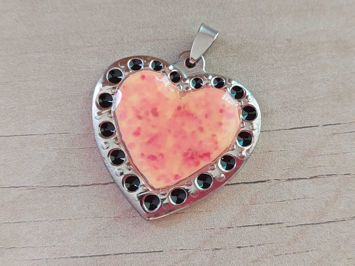 DIJE DE ACERO CORAZÓN ESMALTADO CORAL CON LUNARES NEGROS ALREDEDOR. 37 MM