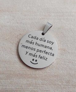 DIJE DE ACERO MEDALLA 25 MM CON LEYENDA "CADA DÍA SOY MAS HUMANA, MENOS PERFECTA Y MAS FELIZ".