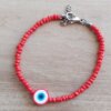 PULSERA DE TANZA CON MOSTACILLAS ROJAS Y OJO TURCO ROJO CON TERMINAL DE ACERO. LARGO 18 + 3 CM EXT.