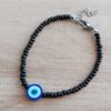 PULSERA DE TANZA CON MOSTACILLAS NEGRA Y OJO TURCO CON TERMINAL DE ACERO. LARGO 18 + 3 CM EXT.