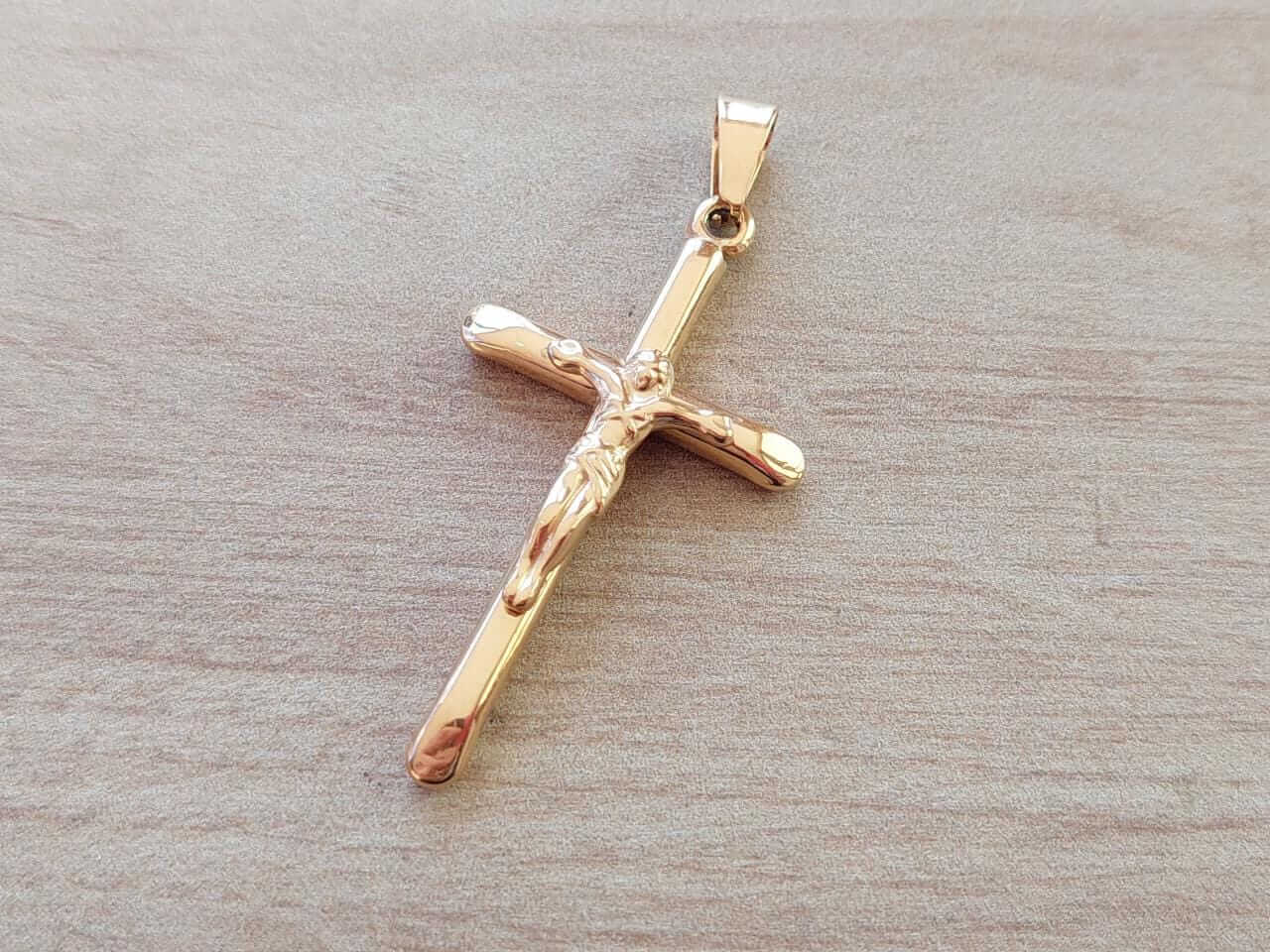 DIJE DE ACERO DORADO CRUZ PALITO CON CRISTO. 29 X 50 MM