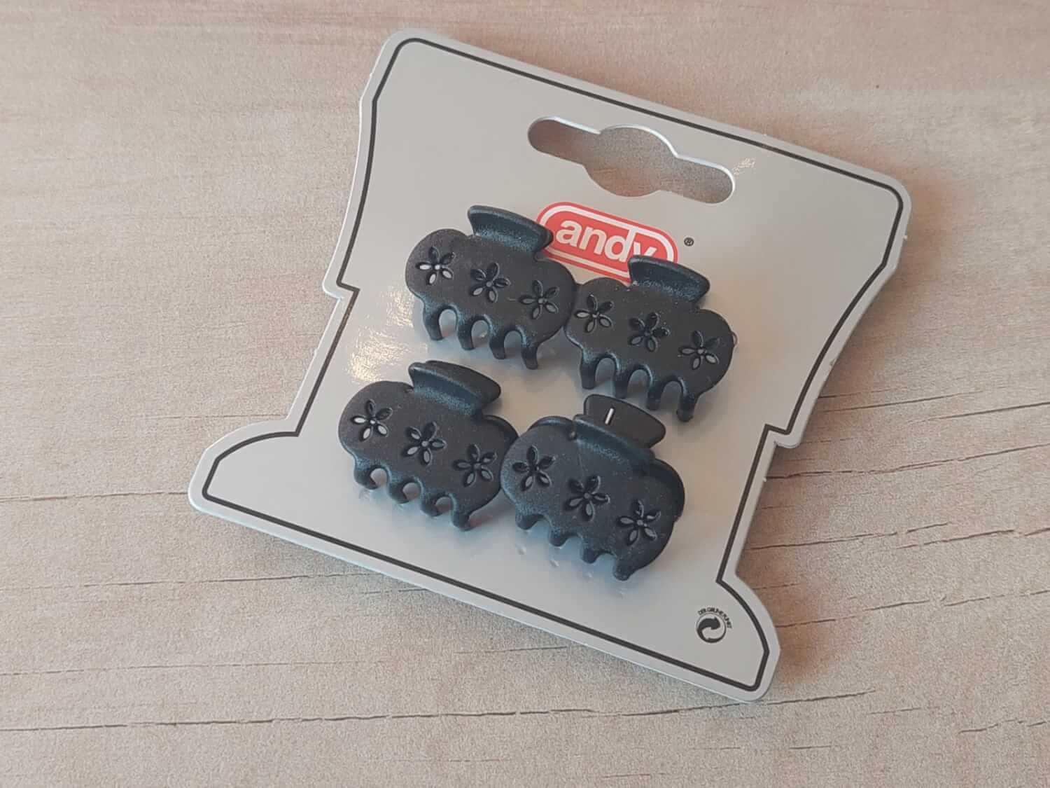 PACK DE 12 BLISTER BROCHES DE PLÁSTICO 25 MM CON FLORCITAS CALADAS X 4 UNIDADES COLOR NEGRO.
