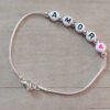 PULSERA DE ACERO BLANCO COLA DE RATON CON BOLITAS Y LEYENDA "AMOR" EN APLIQUES BLANCOS PASANTES CON CORAZON FUCSIA. LARGO 19 CM.