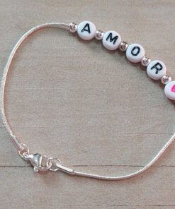 PULSERA DE ACERO BLANCO COLA DE RATON CON BOLITAS Y LEYENDA "AMOR" EN APLIQUES BLANCOS PASANTES CON CORAZON FUCSIA. LARGO 19 CM.