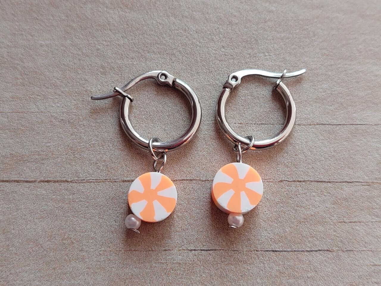ARO DE ACERO ARGOLLA 14 MM CON DIJE NARANJA Y BLANCO COLGANTE.