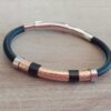 PULSERA DE CAUCHO REGULABLE CON CENTRO EN ACERO ROSE TRABAJADO Y DETALLES EN ACERO NEGRO.