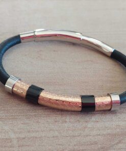 PULSERA DE CAUCHO REGULABLE CON CENTRO EN ACERO ROSE TRABAJADO Y DETALLES EN ACERO NEGRO.