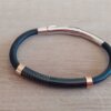 PULSERA DE CAUCHO REGULABLE CON CENTRO EN ACERO NEGRO TRABAJADO Y DETALLES EN ACERO ROSE.