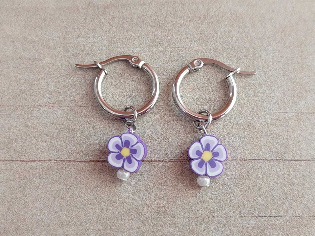ARO DE ACERO ARGOLLA 14 MM CON DIJE FLOR LILA COLGANTE.