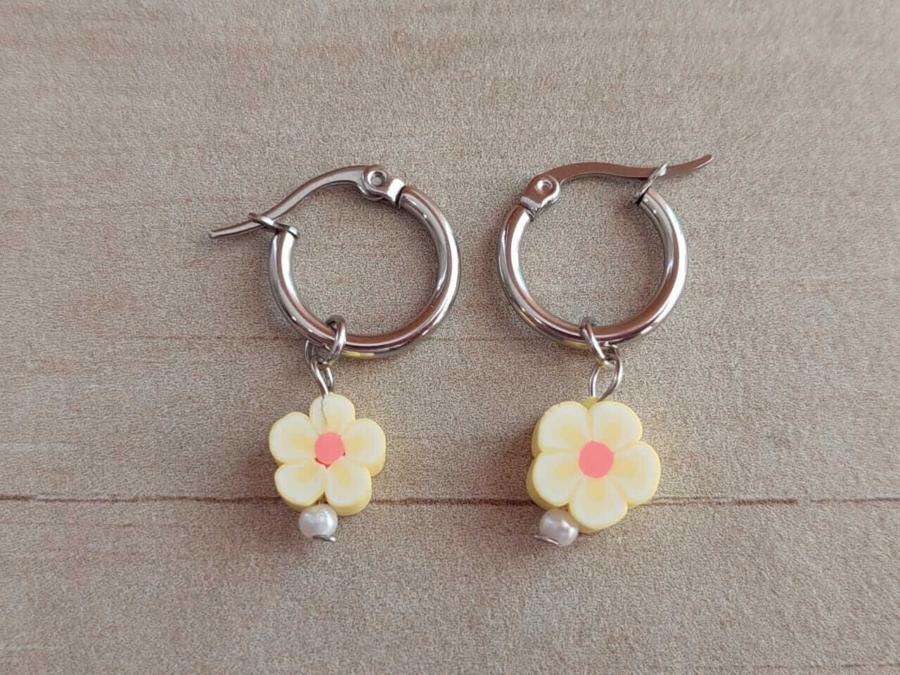 ARO DE ACERO ARGOLLA 14 MM CON DIJE FLOR AMARILLA COLGANTE.