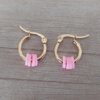 ARO DE ACERO DORADO ARGOLLA 14 MM CON DONAS COLOR ROSA.