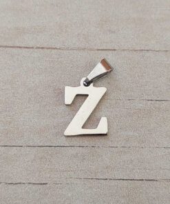 DIJE DE ACERO INICIAL. TAMAÑO APROXIMADO 12 MM X 12 MM.