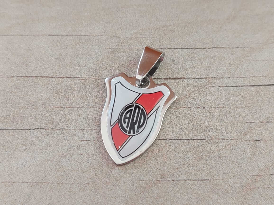 DIJE DE ACERO ESCUDO CARP RESINADO. MEDIDAS 20 X 25 MM