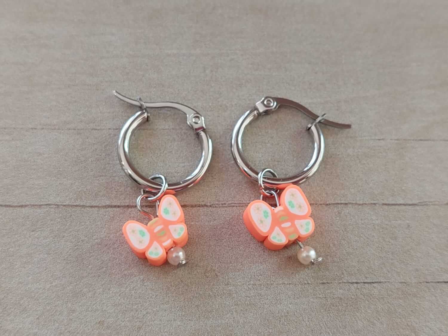 ARO DE ACERO ARGOLLA 14 MM CON DIJE MARIPOSA NARANJA COLGANTE
