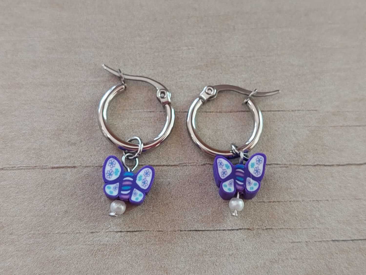 ARO DE ACERO ARGOLLA 14 MM CON DIJE MARIPOSA VIOLETA COLGANTE