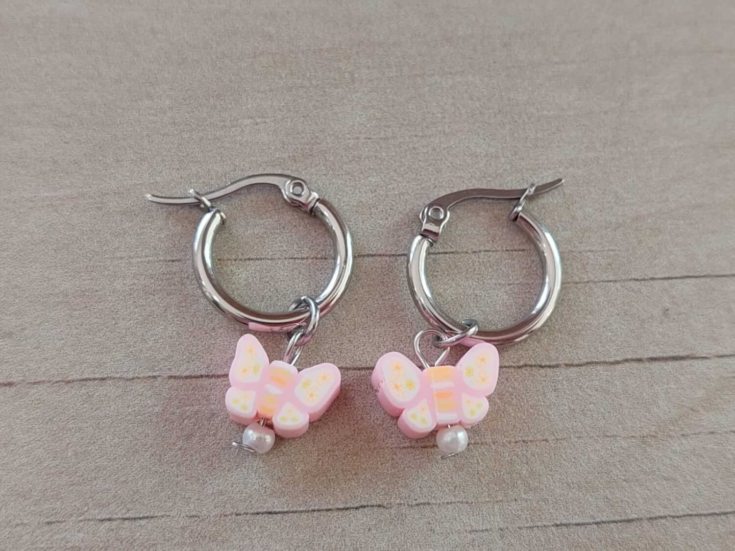 ARO DE ACERO ARGOLLA 14 MM CON DIJE MARIPOSA ROSA COLGANTE