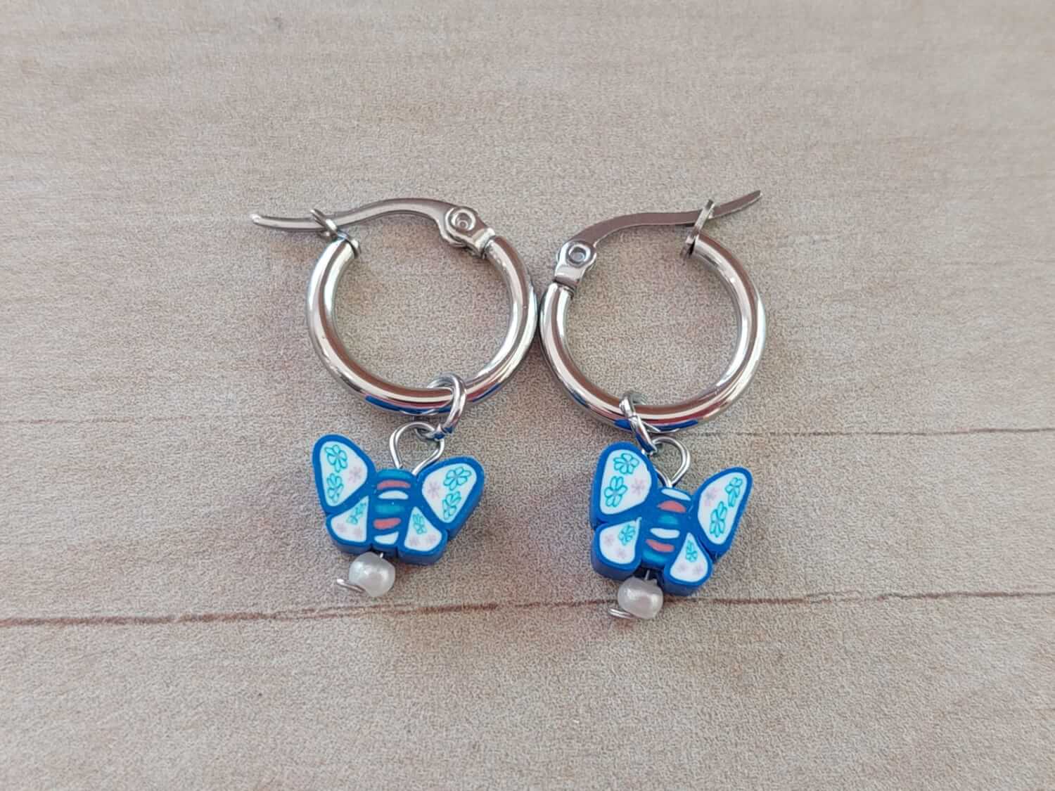 ARO DE ACERO ARGOLLA 14 MM CON DIJE MARIPOSA AZUL COLGANTE
