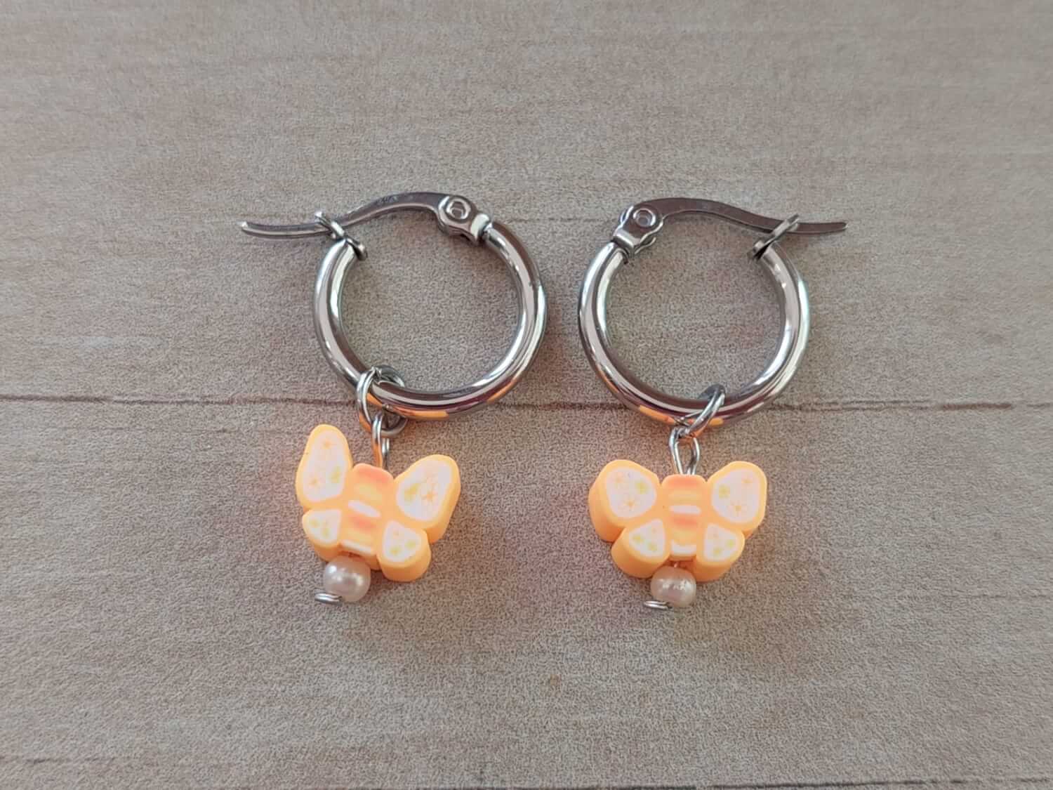ARO DE ACERO ARGOLLA 14 MM CON DIJE MARIPOSA NARANJA COLGANTE