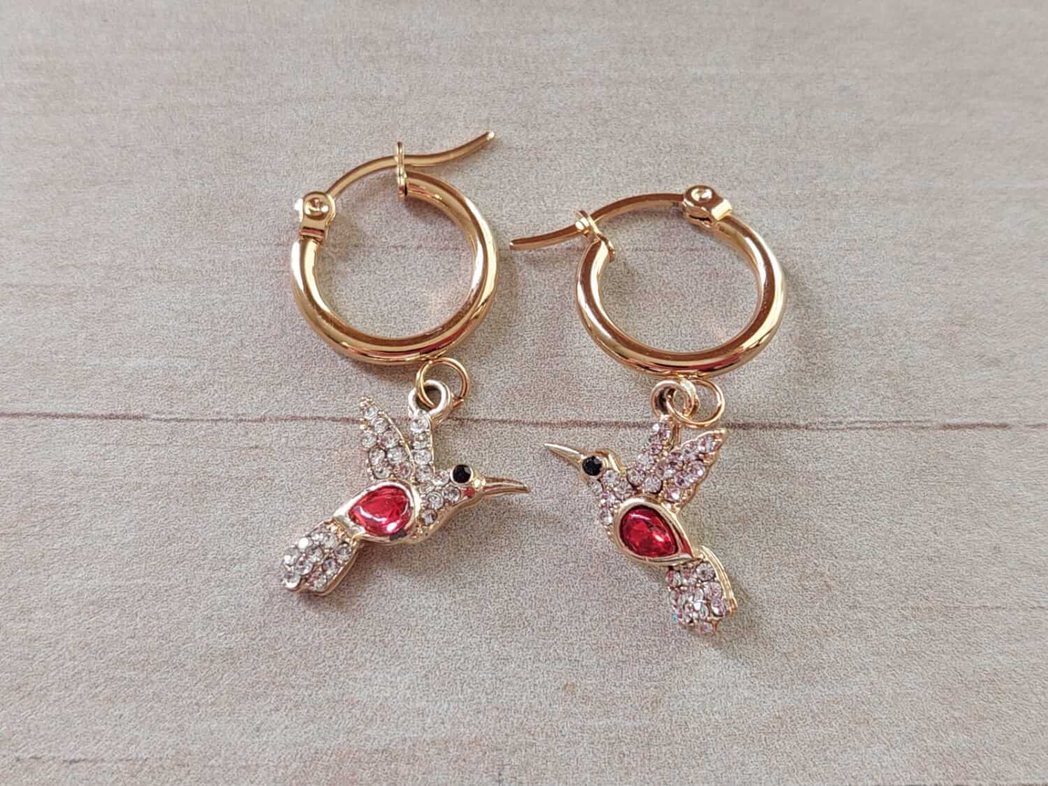 ARO DE ACERO DORADO ARGOLLA 15 MM CON DIJE COLIBRÍ CON CUBIK ROJO