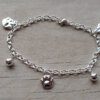 PULSERA DE ACERO BLANCO ESLABÓN TIFFANY CON BOLITAS Y DIJES DE HUELLITAS. LARGO 18,5 CM
