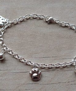 PULSERA DE ACERO BLANCO ESLABÓN TIFFANY CON BOLITAS Y DIJES DE HUELLITAS. LARGO 18,5 CM