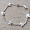 PULSERA DE ACERO BLANCO ROLO 2.0 CON DIJES MARIPOSA ACRÍLICO BLANCO NACARADO. LARGO 18,5 CM