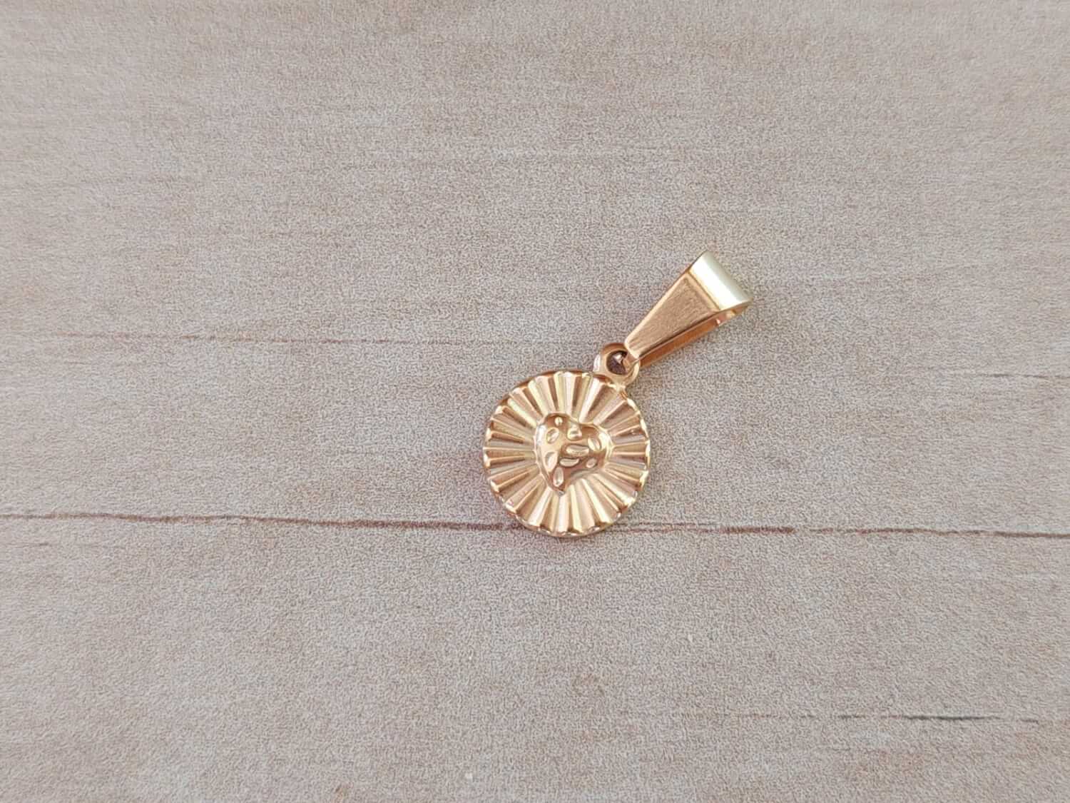 DIJE DE ACERO DORADO MEDALLA 12 MM CON CORAZÓN Y RAYOS.