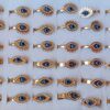 ANILLOS DE ACERO DORADO OJITO TURCO Y VARIOS STRASS X 36 UNIDADES SURTIDOS EN MEDIDAS Y MODELOS. (MEDIDAS DEL 16 AL 19)