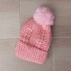 GORRO TEJIDO CON PIEL EN SU INTERIOR COLOR ROSA CON POMPÓN DE PIEL.