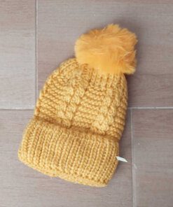 GORRO TEJIDO CON PIEL EN SU INTERIOR COLOR AMARILLO CON POMPÓN DE PIEL.