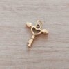 DIJE DE ACERO DORADO LLAVE CON ALAS BOMBE 17 MM