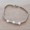 PULSERA DE ACERO DE BOLITAS 3 MM CON TRES ESTRELLAS DE NÁCAR EN EL CENTRO. LARGO 18 CM.