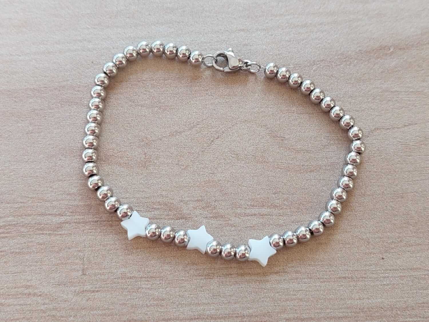 PULSERA DE ACERO DE BOLITAS 3 MM CON TRES ESTRELLAS DE NÁCAR EN EL CENTRO. LARGO 18 CM.