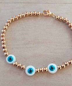 PULSERA DE ACERO DORADO BOLITAS 3 MM CON TRES OJITOS TURCOS DE NÁCAR EN EL CENTRO. LARGO 18 CM.