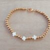 PULSERA DE ACERO DORADO BOLITAS 3 MM CON TRES CRUCES DEL EQUILIBRIO DE NÁCAR EN EL CENTRO. LARGO 18 CM.